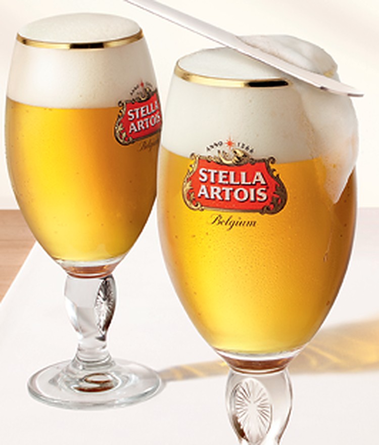 Stella Artois v originálním kalichu, večerní město